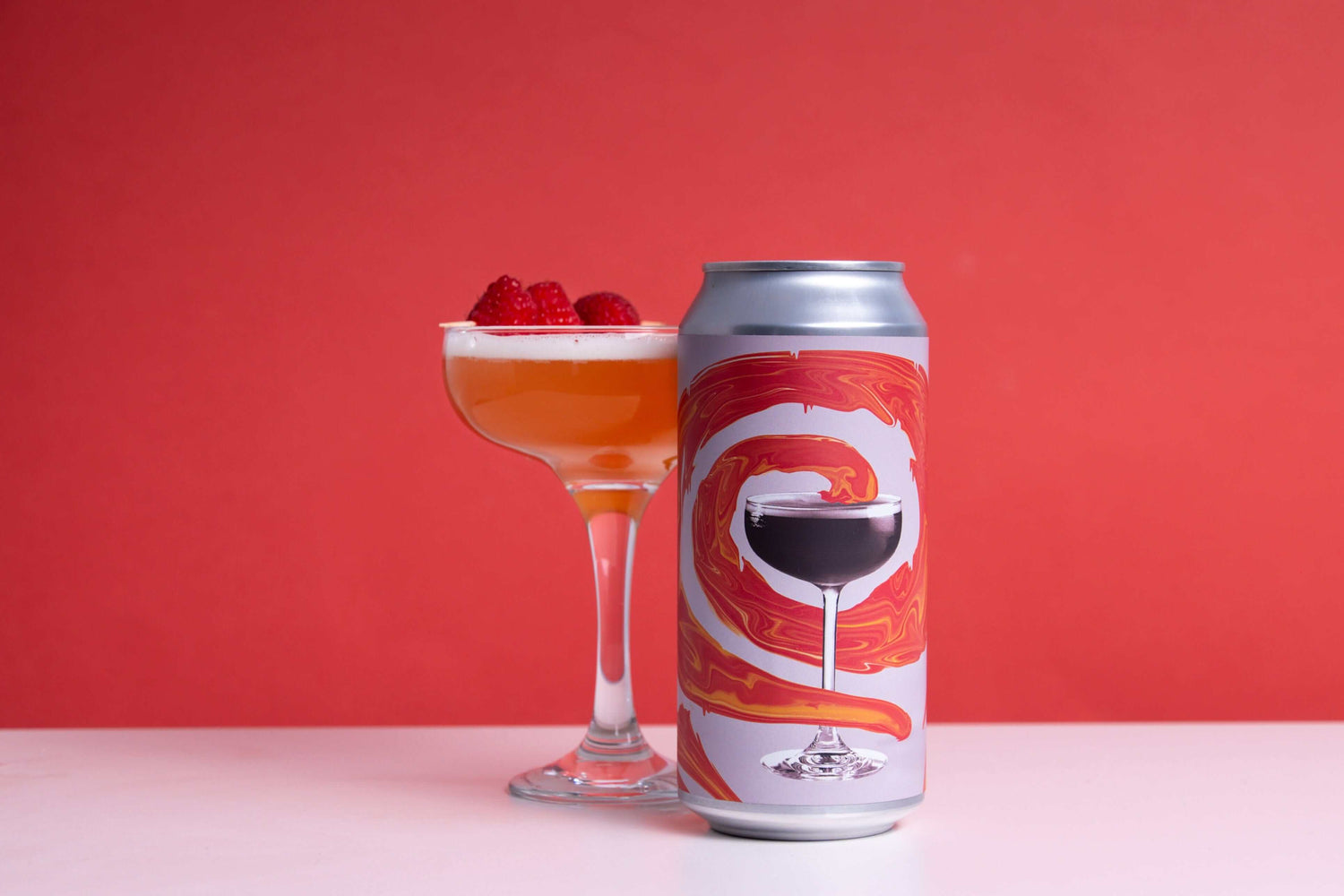 Northern Spirits French Martini Pale Ale can and cocktail glass with raspberries against a red background.